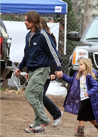 24. 克里斯蒂安·贝尔 (Christian Bale) 牵着女儿一起逛街，他们正在寻找一颗圣诞树。 