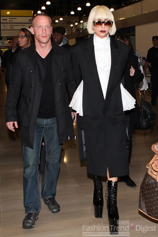 2. Lady Gaga仍是以雷母的身份出现在机场上，她选择色了一件黑色长大衣和超厚的木履高跟鞋和圆形墨镜，也只有她总是能超越时尚，带给人们不少的惊喜。 