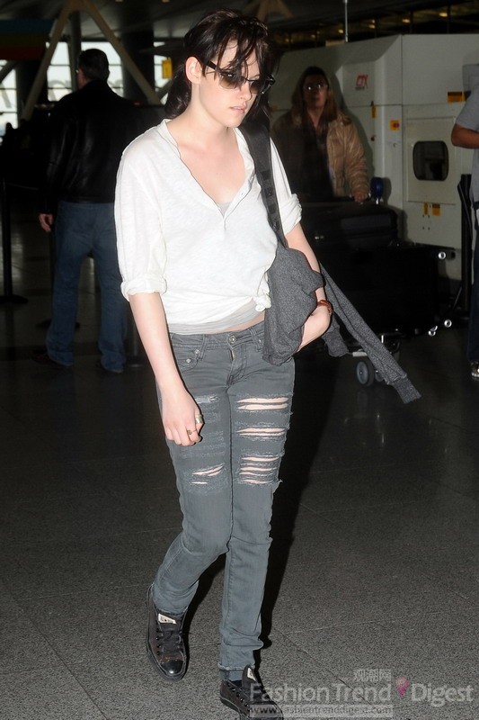 13. 克里斯汀•斯图尔特 (Kristen Stewart) 的机场造型看起来有点颓废，撕裂的牛仔、松垮的白色衬衫，难道她也在学犀利哥的造型？ 