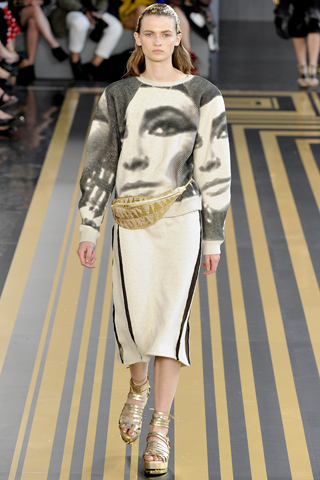 5. Topshop Unique埃及主題的時裝秀當然少不了埃及艷后，伊麗莎白女王飾演的埃及艷后的圖像被設計在寬松的燈籠袖的上衣上，特別是肩部的設計松垮或者圓滑，女性纖細的身材被賦予了埃及女王的權利，就連模特的頭發上都被燙上了金色，配上金色腰包和鞋履，多了男性的硬朗感。 