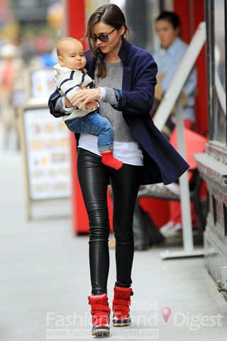8. 米蘭達可兒（Miranda Kerr）抱著自己的孩子Flynn出門，海軍藍大衣、皮革緊身褲和休閑運動鞋，時尚而前衛。 
