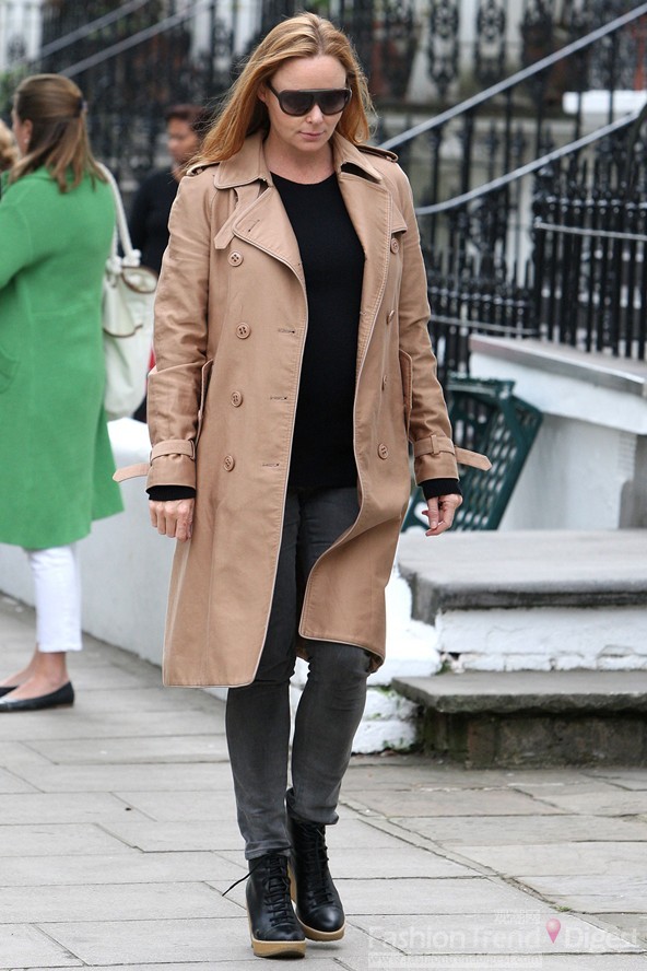 4. 斯特拉•麦卡特尼 (Stella McCartney)在黑色服饰上外搭一件驼色风衣，深色牛仔裤、系带休闲靴都成为她劲酷造型的必搭元素。