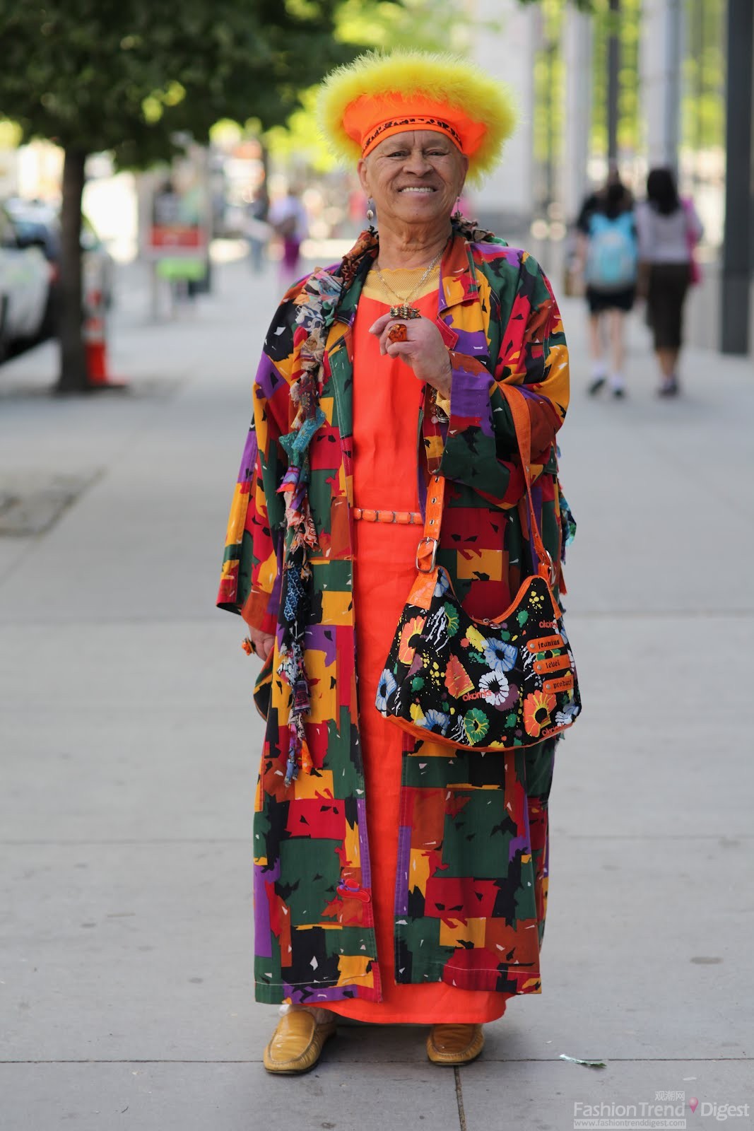 10. 这位老太太穿得相当花哨，橘色长裙还不够，硬是搭了一件色块大衣和印花包，街头的她顿时引起了摄影师的注意。