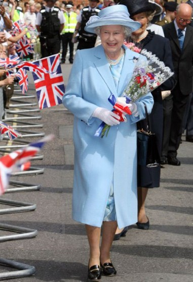 2. 女王伊丽莎白二世(Queen Elizabeth II)选择了一件淡蓝色套装，除了帽子颜色相一致，她还搭配了奢华的珠宝项链和白色手套。