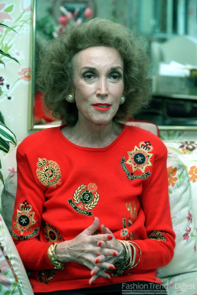 12. 1990年3月，海伦•格蕾•布朗(Helen Gurley Brown)再次选择了中国红的毛衣，不过毛衣上的金色徽章图案和金色首饰形成了呼应的效果。